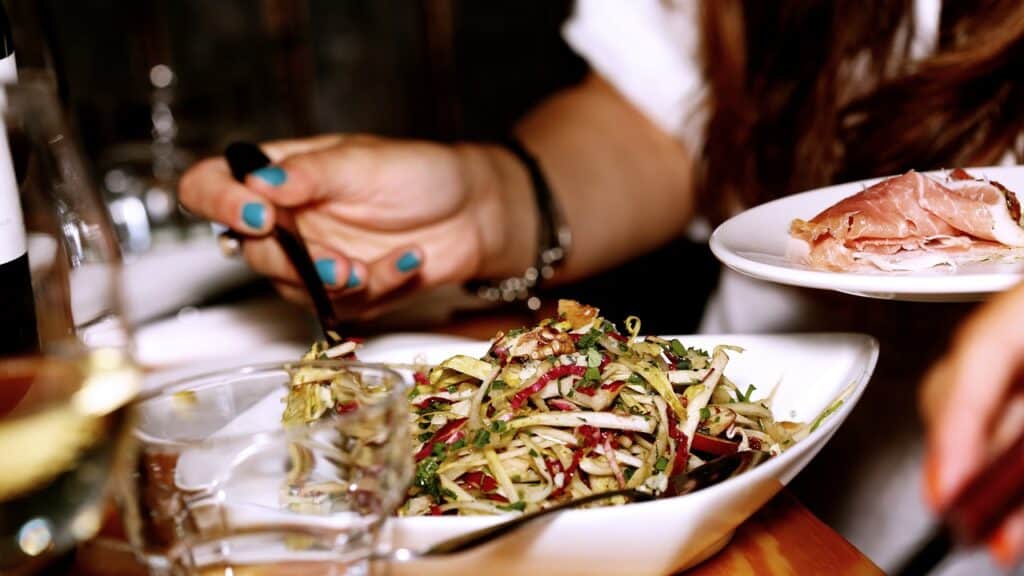 hand spooning salad online plate