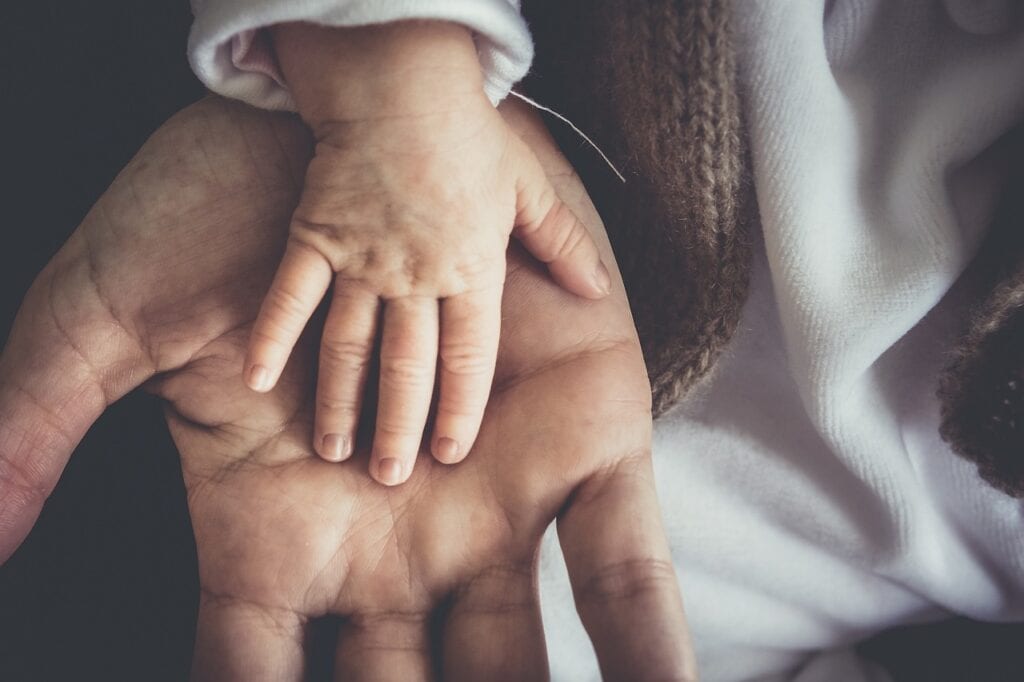 pic of a baby's hand on top of an adult's hand