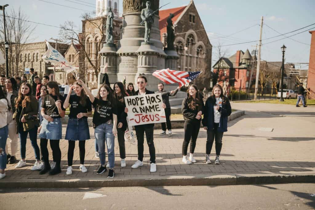 Christians holding Jesus signs and American flag on street