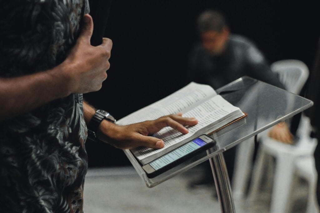 Pulpit with phone and Bible, hand of man preaching