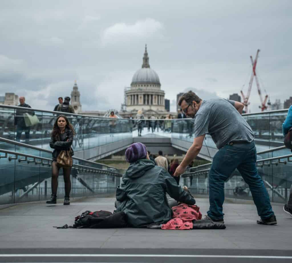 man giving money to beggar