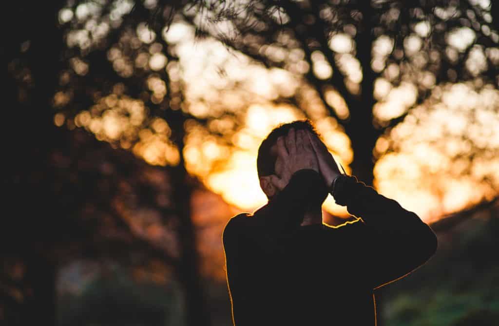 unmarried man covering face in despair