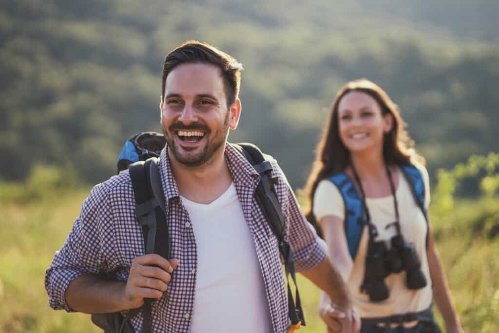 An illustration about biblical leadership. A man and woman are lauging as they walk down a trail. The man is holding his wife's hand and leading her.